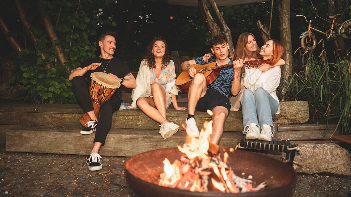 Jeunes gens assis autour d’un feu de camp – Aventure Vanlife