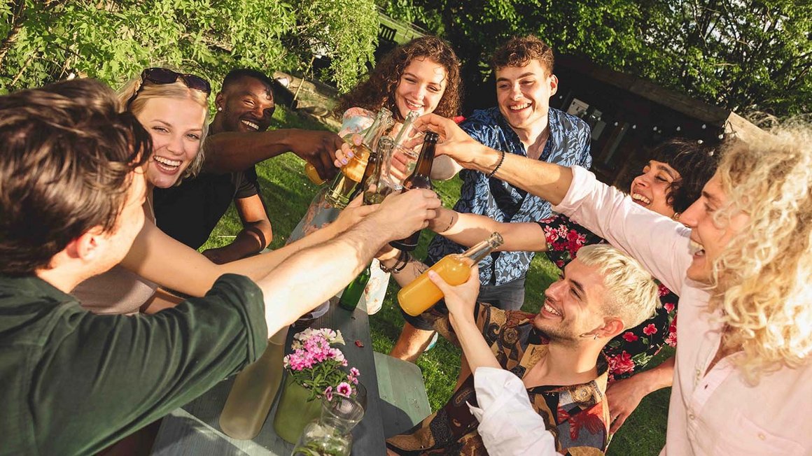 Un groupe de jeunes porte un toast avec des verres. 