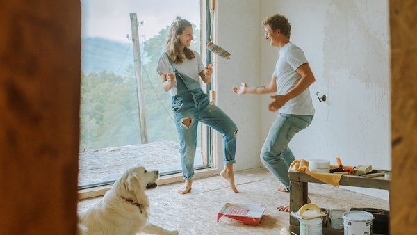Un couple danse avec son chien dans sa nouvelle maison - financement de la construction