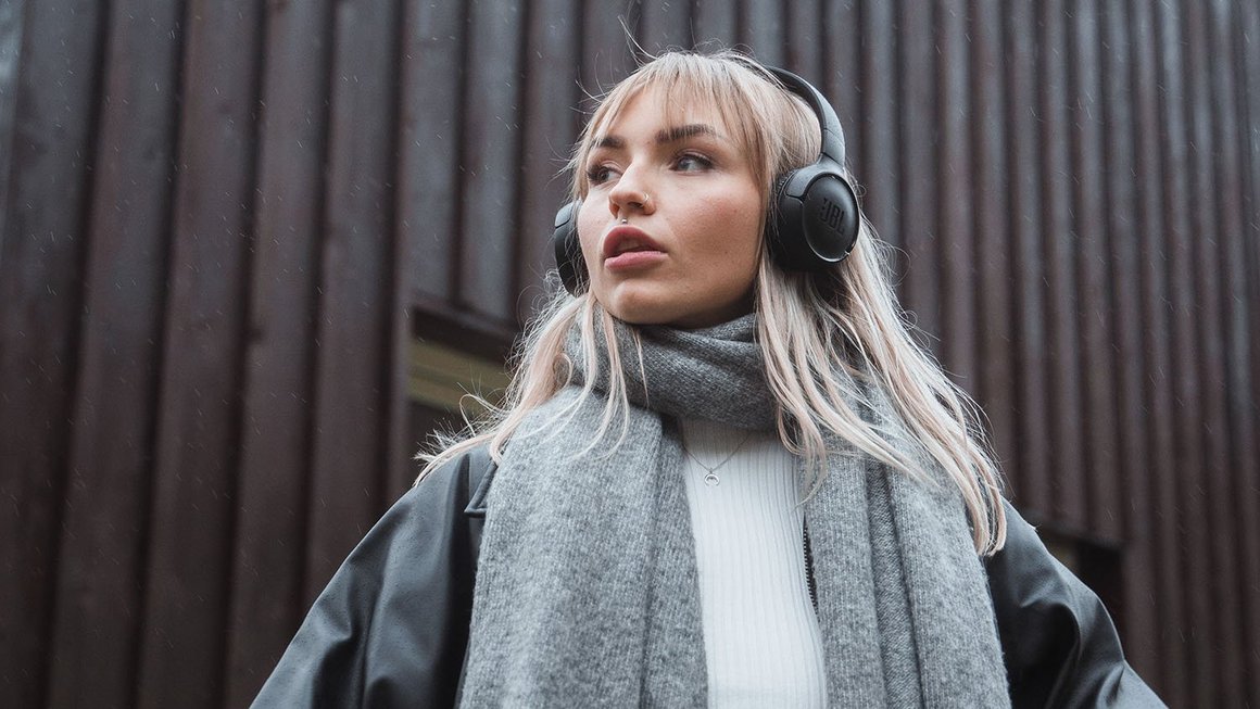 Jeune femme avec des écouteurs regardant au loin