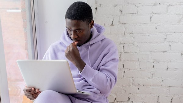 En 5 etapes vers votre prevoyance vieillesse Etudiant assis devant un ordinateur portable en train de ruminer