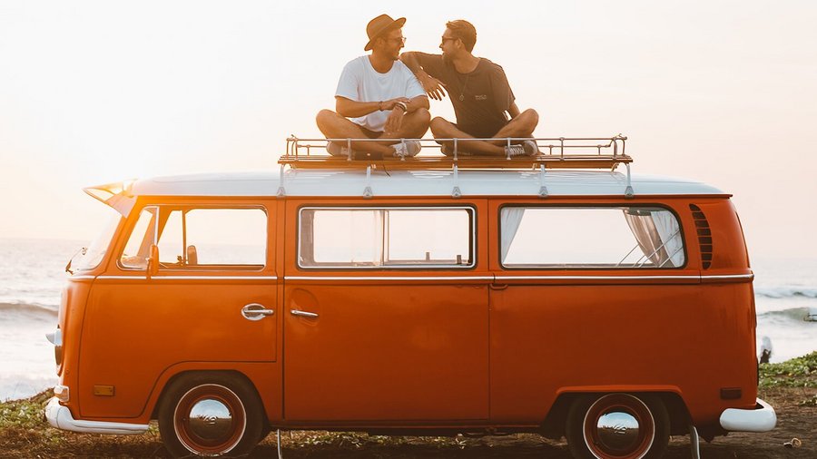 Zwei junge Männer sitzen auf einem Van – Vanlife 