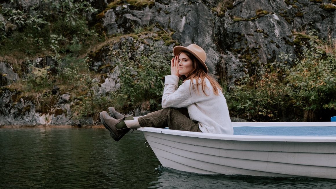 Femme assise dans un bateau - Voyager a l'etranger