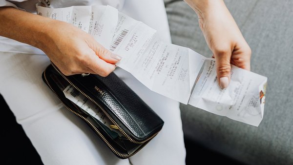 [Translate to français:] Frau hat eine Quittung in der Hand – steigende Preise