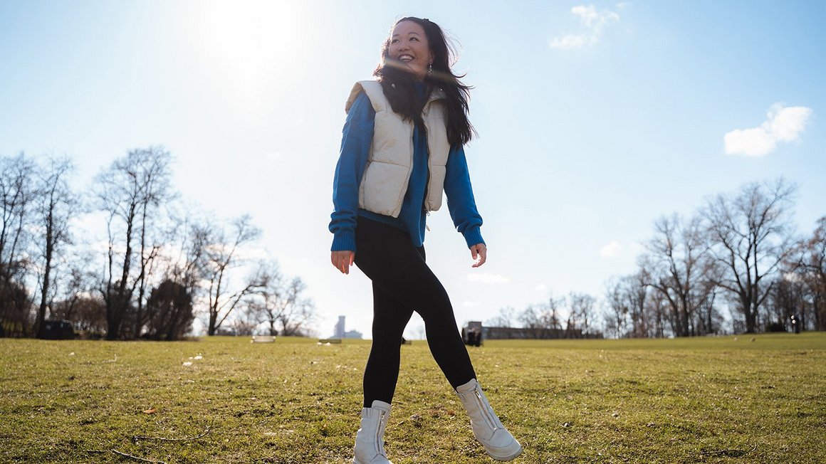 Jeune etudiante souriante sur une pelouse