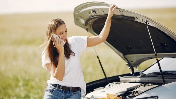 Une femme en panne au bord de la route avec sa voiture