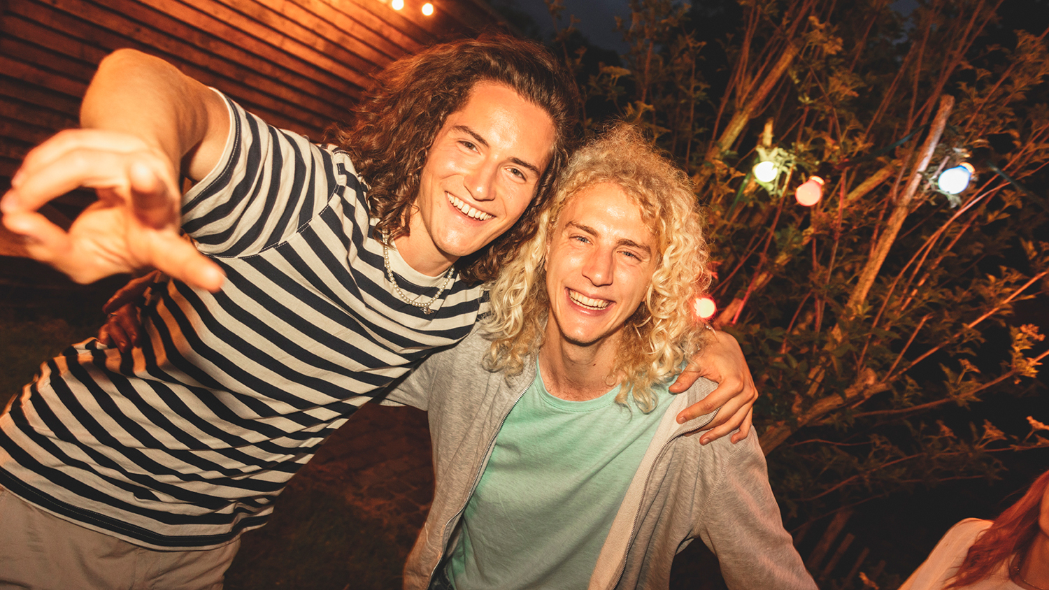 Deux jeunes hommes sourient à la caméra
