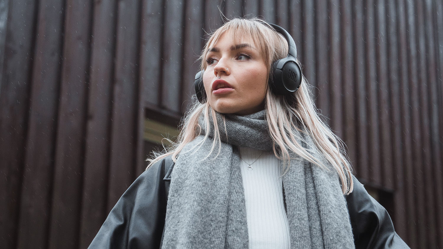 Jeune femme avec des écouteurs regardant au loin