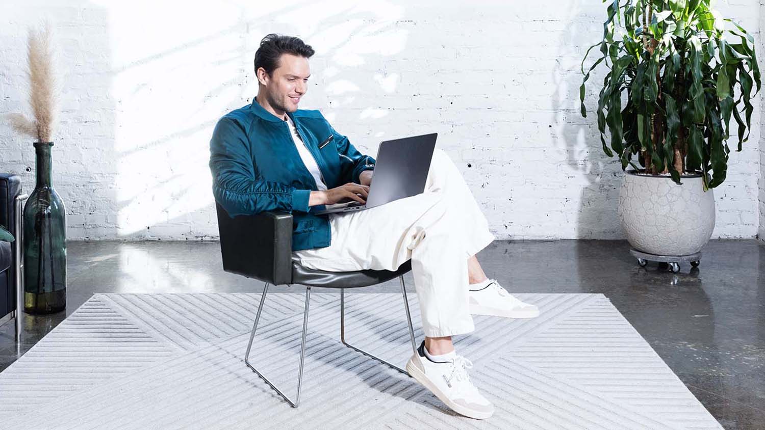 Jeune homme travaillant sur son ordinateur portable et planifiant son budget.