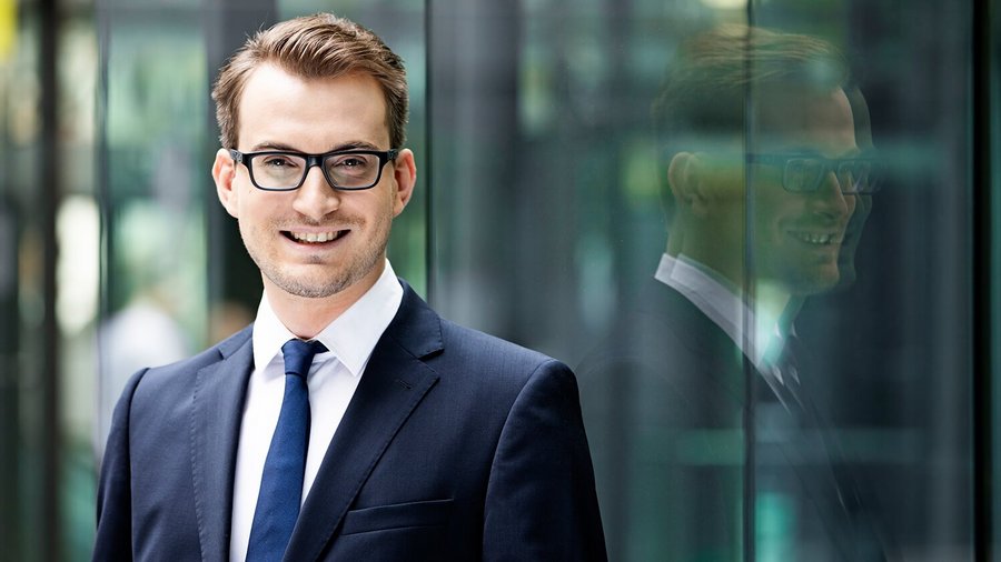 Un homme souriant avec des lunettes devient conseiller financier OVB