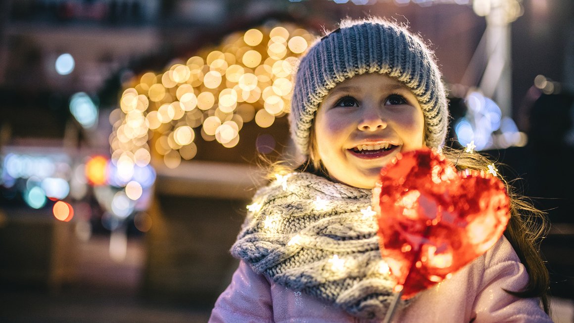 Mädchen mit Herz und Weihnachtslichtern – Geld richtig anlegen Mädchen mit Herz und Weihnachtslichtern – Geld richtig anlegen
