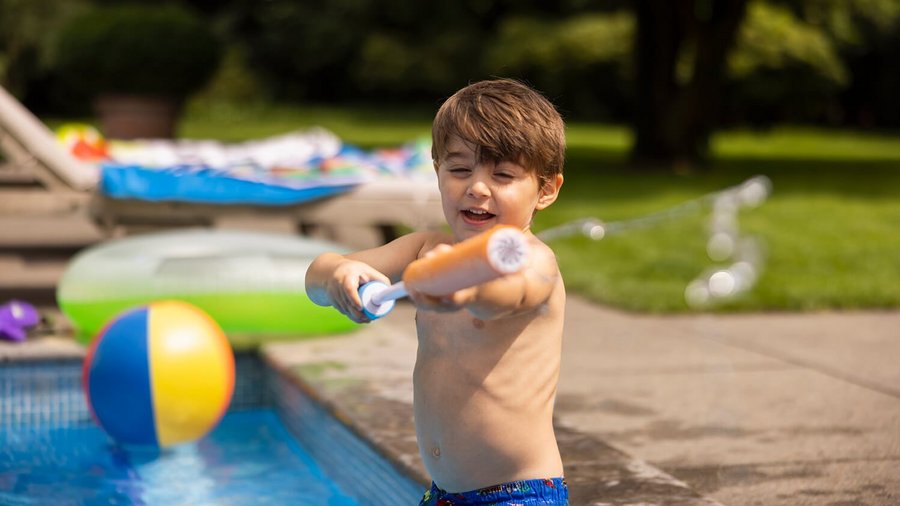 Kind am Pool mit Wasserpistole – Sicher verreisen  