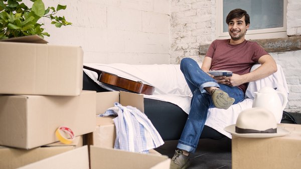 Junger Mann zufrieden in erster eigenen Wohnung